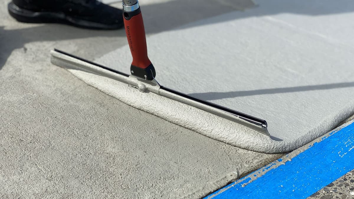 Concrete repair material being applied to a damaged concrete surface