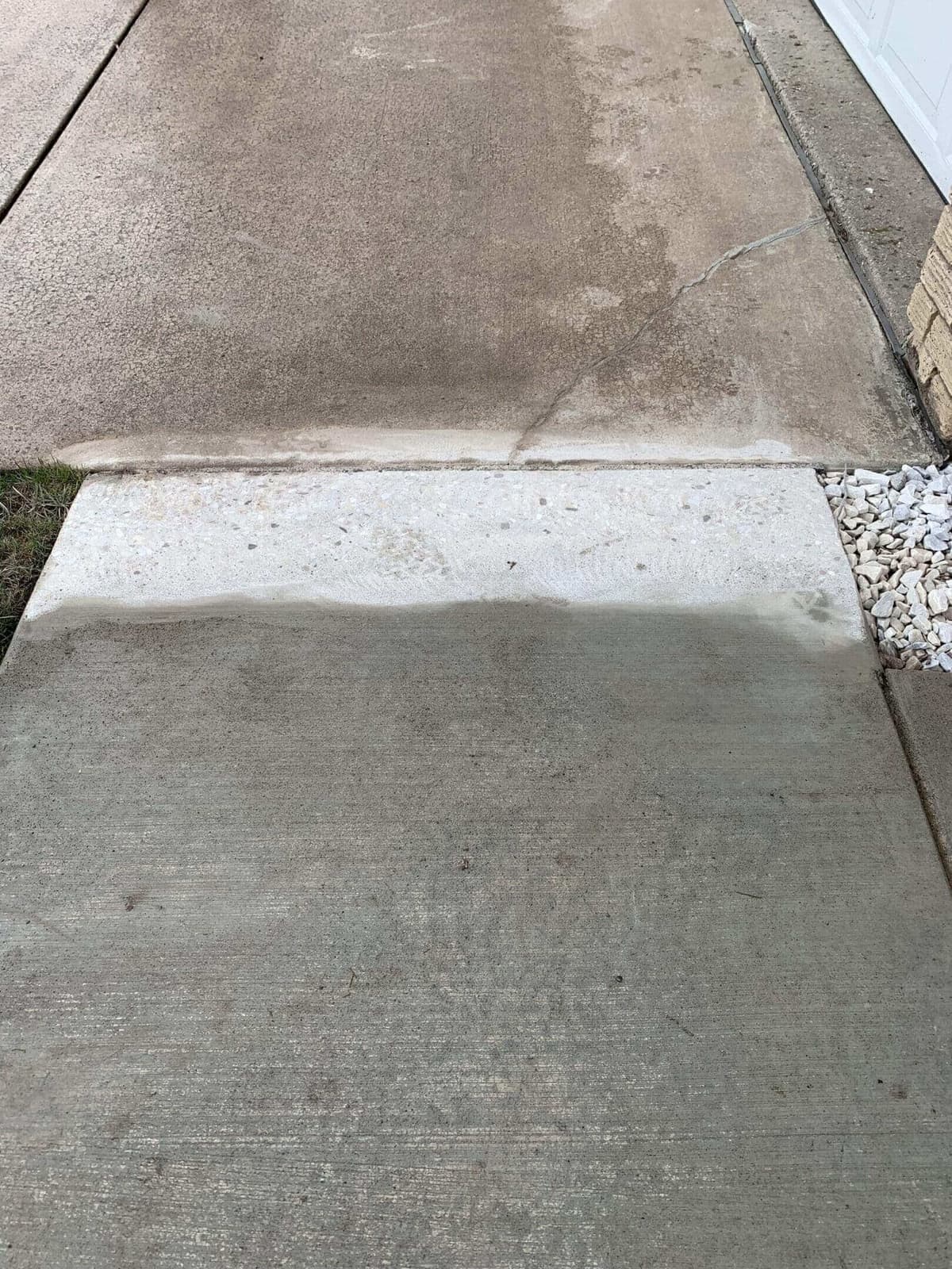 Concrete driveway showing visible cleaning and repair results